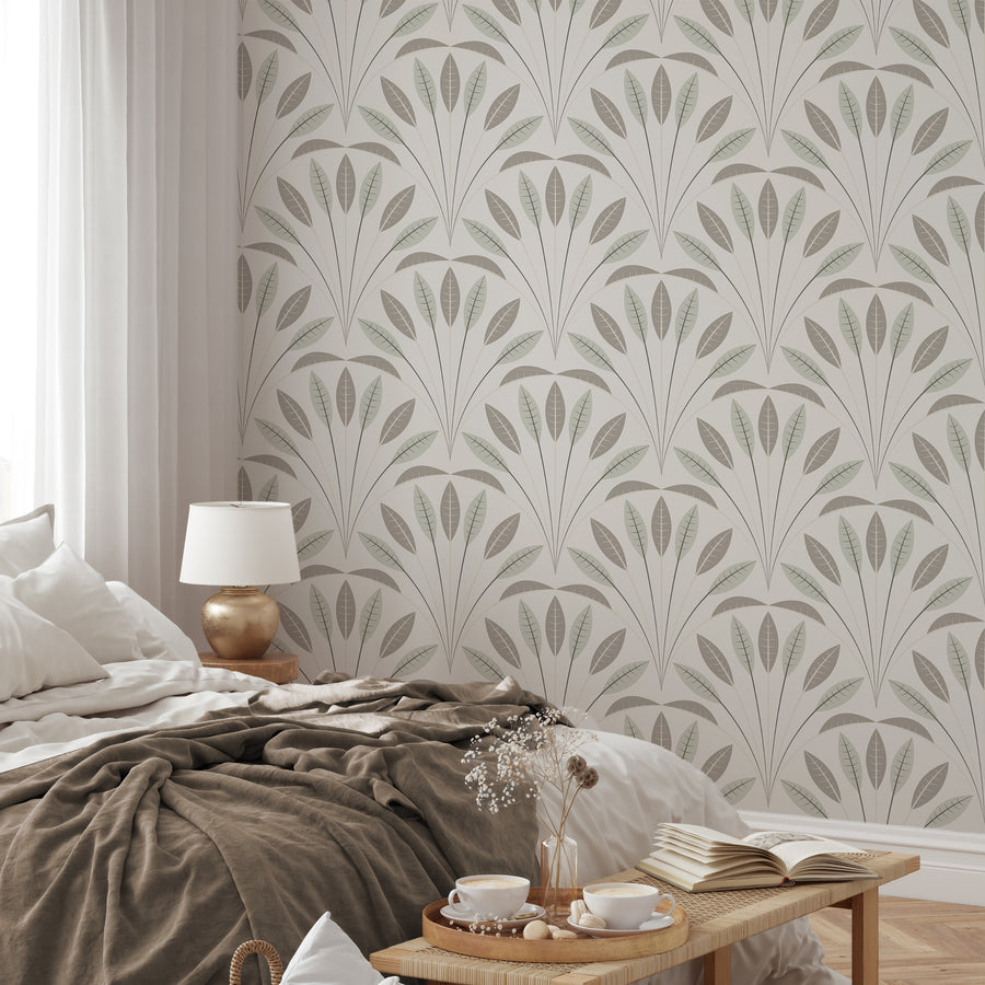 A natural styled bedroom with a bed, side table and bench at the end of the bed featuring 'Bonnie' which is a pastel botanical wallpaper featuring soft green, sage and brown illustrated leaves on a light neutral background in a calming repeating foliage pattern.