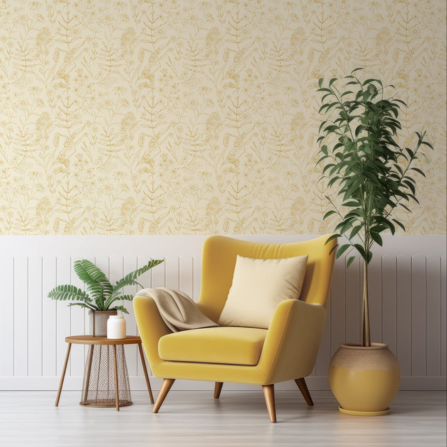 A living room with a yellow arm chair and leafy plants either side of it featuring 'Carmen' which is a yellow wallpaper featuring delicate botanical outlines of flowers, leaves and leafy stems in mustard tones on a soft pale yellow background in a repeating floral pattern.