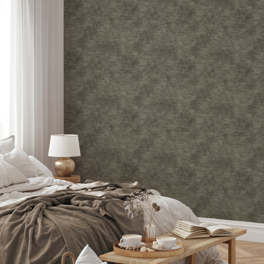 A soft furnished bedroom featuring the Chiffon wallpaper which is a muted green fabric-effect with a soft textured finish and natural woven appearance.