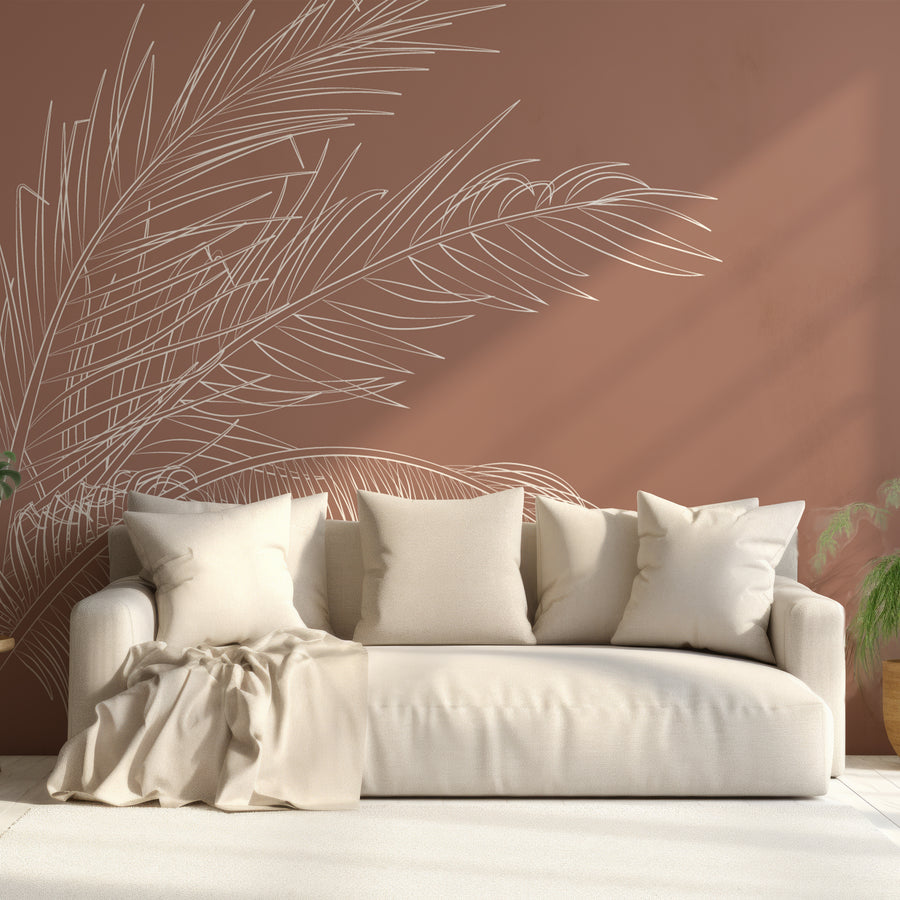 A living room with soft, cream furnishings featuring Donda wallpaper which shows large minimalist palm leaves in a repeating line-art pattern on a soft blush pink background.