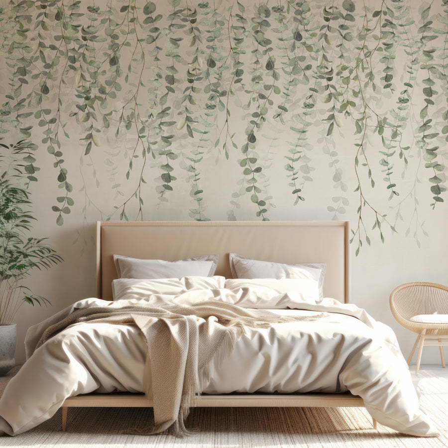 A bedroom with light coloured furnishings showng 'Joanna' which is an olive green wallpaper featuring cascading olive branches with golden stems on a subtle textured background in a repeating botanical pattern.