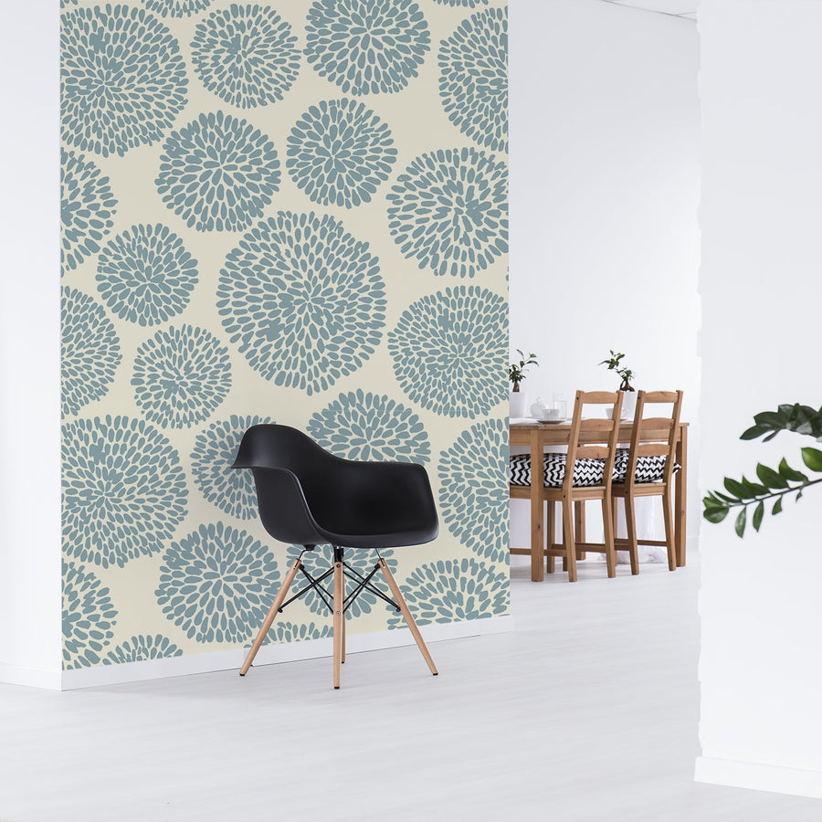 An opened planned kitchen diner with a black modern chair with a brown dining table with a feature wall of the wallpaper Auxence Bleu which is blue and cream wallpaper with an abstract repeating pattern of segmented circles in soft blue and neutral tones.