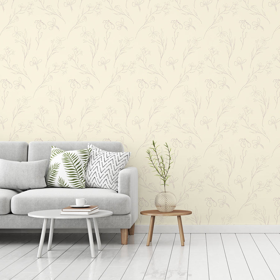 A living room with a grey sofa with two small tables bedside it, showing 'Micaela' which is a modern wallpaper featuring delicate flower outline illustrations in a simple repeating botanical pattern with soft muted tones.